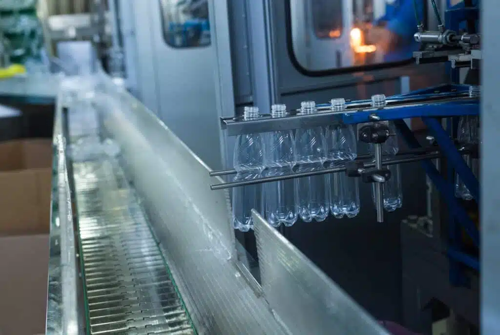Plastic water bottles on conveyor and water bottling machine industry